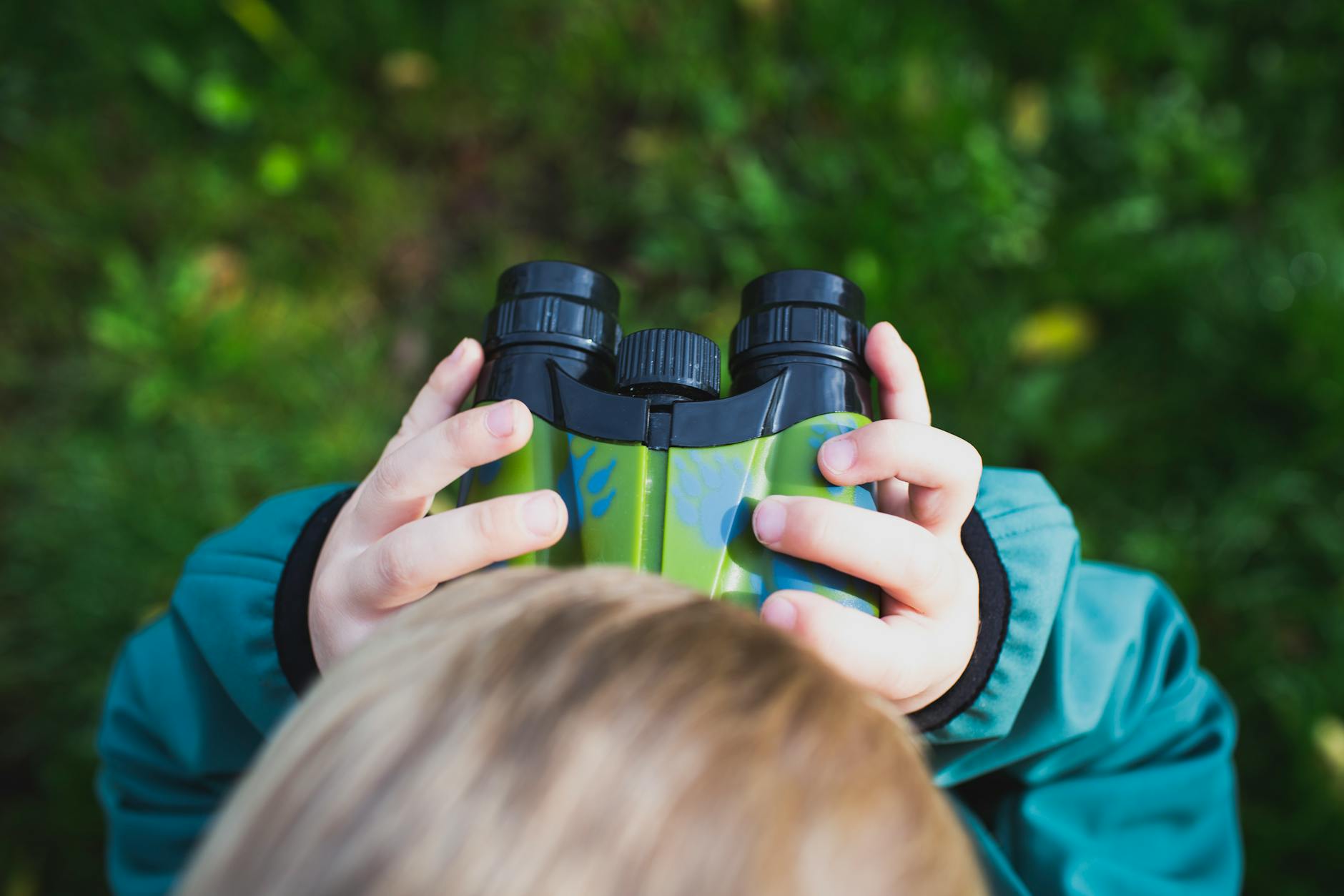 Child using binoculars to spot wildlife on a Laikipia family safari